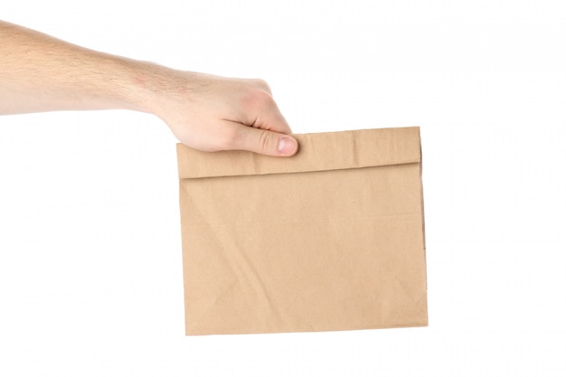 Male hand holds paper bag, isolated on white