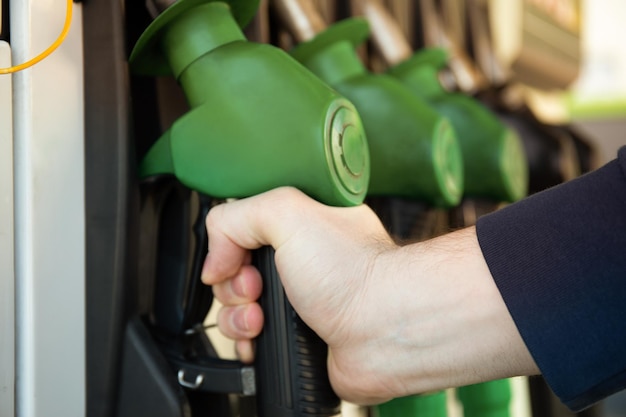 Male hand holds refueling gun concept of refueling a car