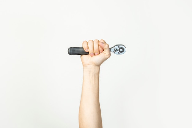 Male hand holds a wrench on a light isolated