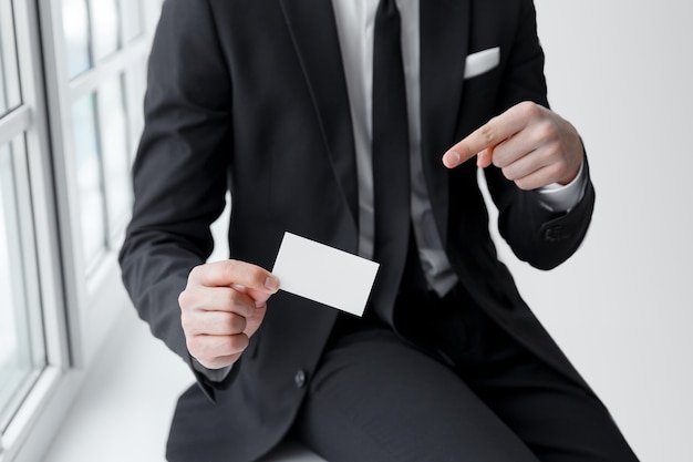 Male hand indicating an empty business card - closeup shot