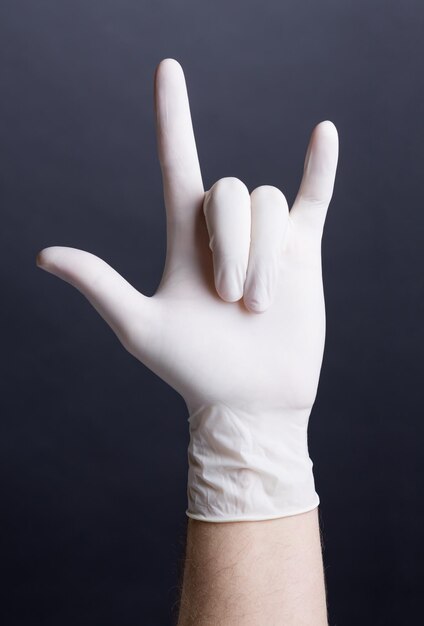 Male hand in latex glove love sign