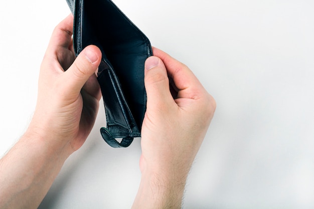 Male hand opening an empty wallet on white background. World economic crisis. Financial problem jobless, bankruptcy concept.