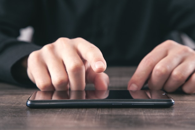 Male hand pointing over smartphone. Technology