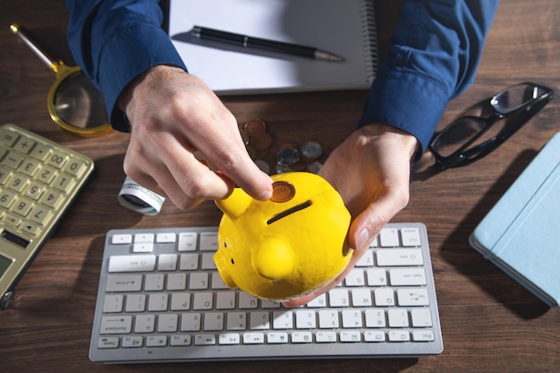 Male hand putting coin to piggy bank Saving