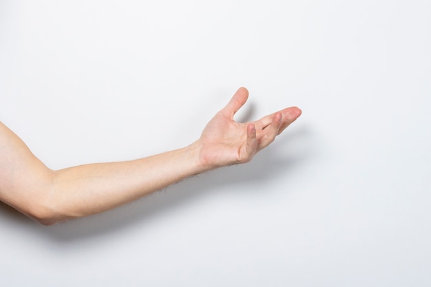 Photo male hand reaches for something on a light isolated