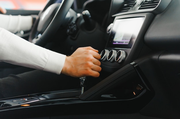 Male hand on the shift lever of the transmission in the car