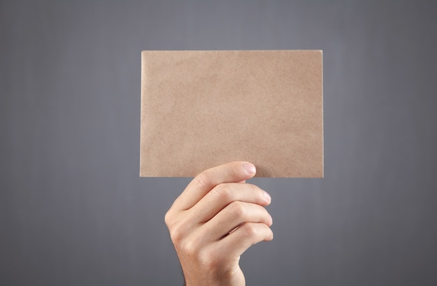 Male hand showing empty brown paper.