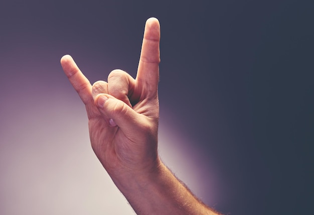 The male hand shows a symbol of heavy metal