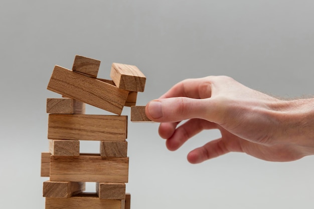 Male hand stacking wooden blocks Business development and growth concept