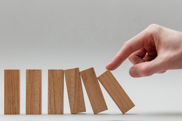 Foto mano maschile che ferma i blocchi di legno che cadono