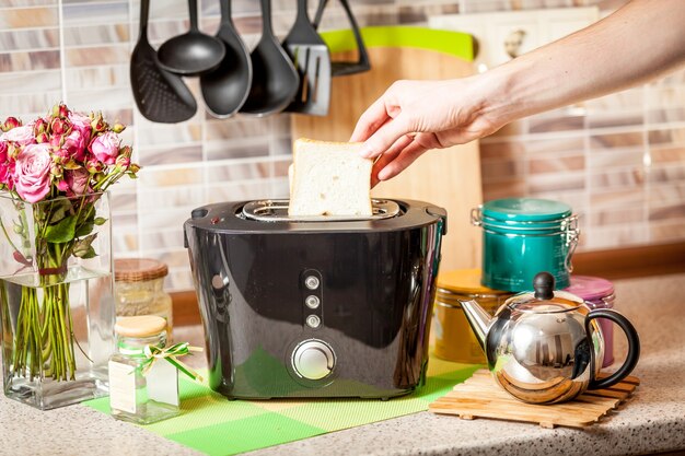 Male hand taking baked toast out of toaster