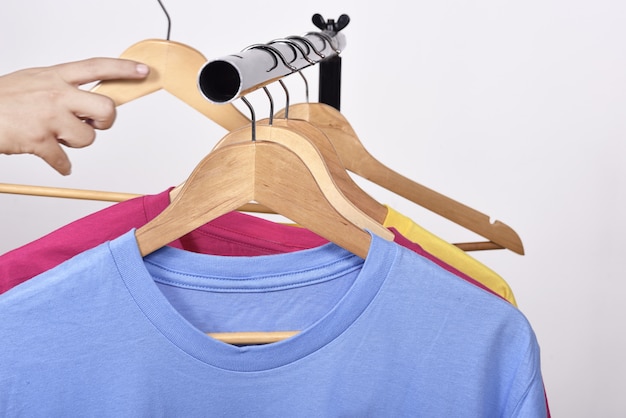 Male hand taking a hanger for clothes from shelf