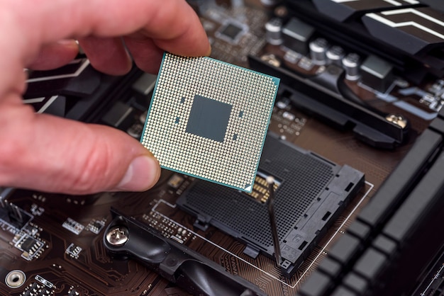 Male hand taking off CPU chip from motherboard