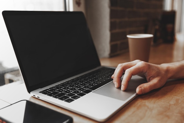 Photo male hand on the touchpad of a laptop with a black screen