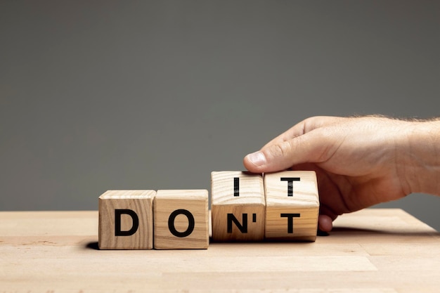 Photo male hand turning wooden cube block and change sense of word do it conceptual image about human