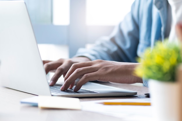 Male hand typing on laptop keyboard.