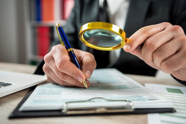 Male hand using magnifying glass and work with 1040 tax form