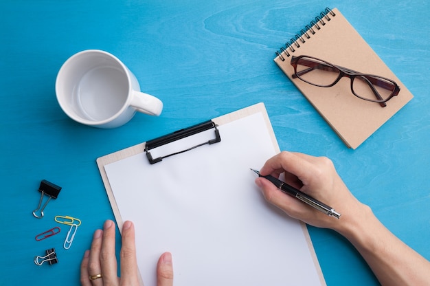 Male hand with pen writing on blank paper 