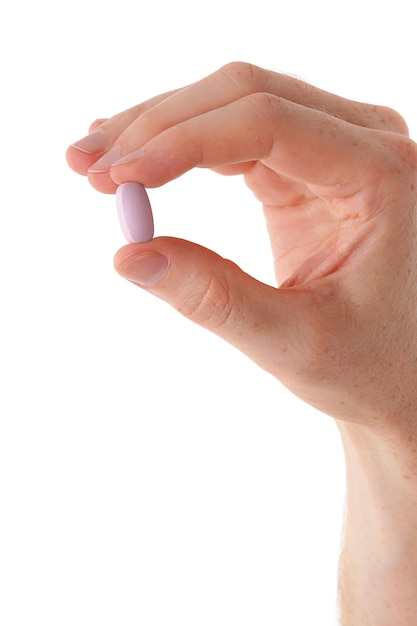 Male hand with pill on white
