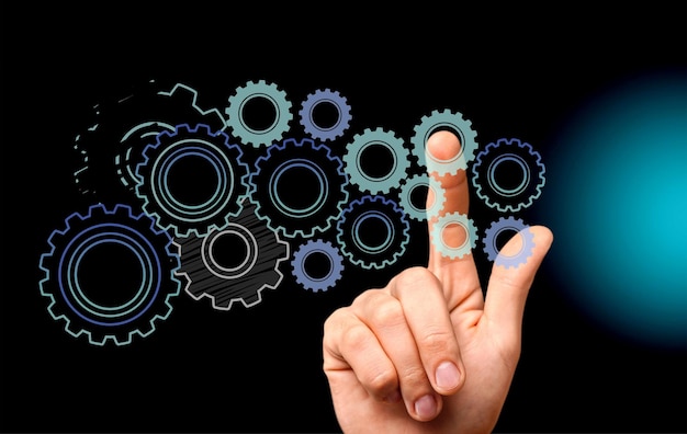 Male hand with pointing finger up and Heap of gears over grey background