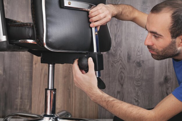 Male hands adjusts office chair.