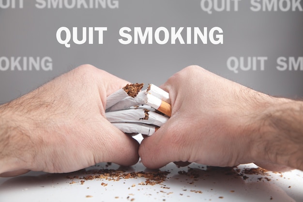 Photo male hands breaking cigarettes