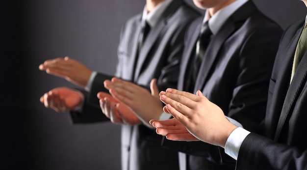 Male hands clapping on black, side-view