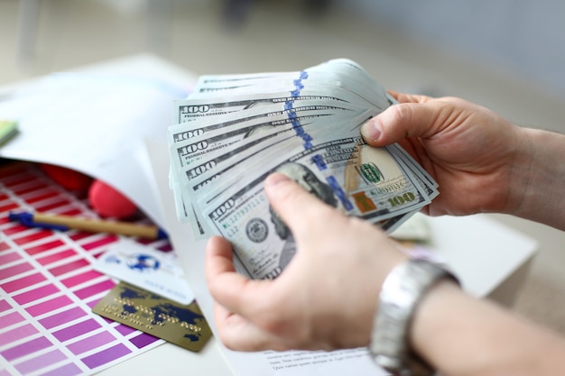 Male hands counting money from huge pack