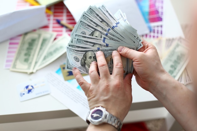 Male hands counting money from huge pack