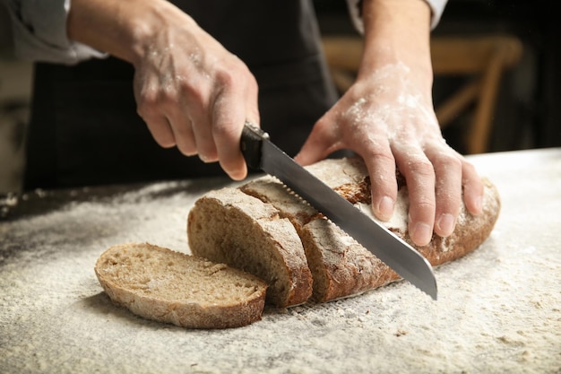male hands cutting homemade bread closeup
