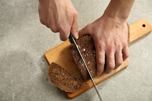 Male hands cutting homemade bread closeup