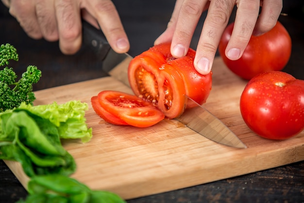 Photo male hands cutting vegetables for salad