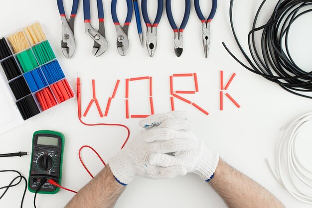 Male hands in gloves with a tool on a white background