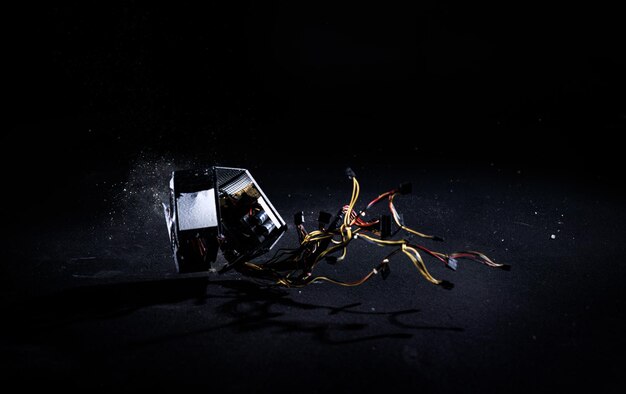 Photo male hands hitting hard pc power supply on the floor demolishing and breaking psu isolated on a