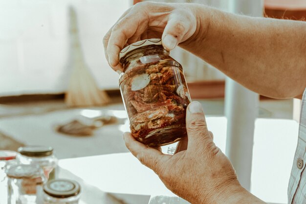 Male hands hold glass jar with dried tomatoes