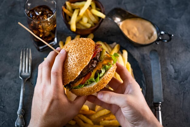 ハンバーガーを保持している男性の手