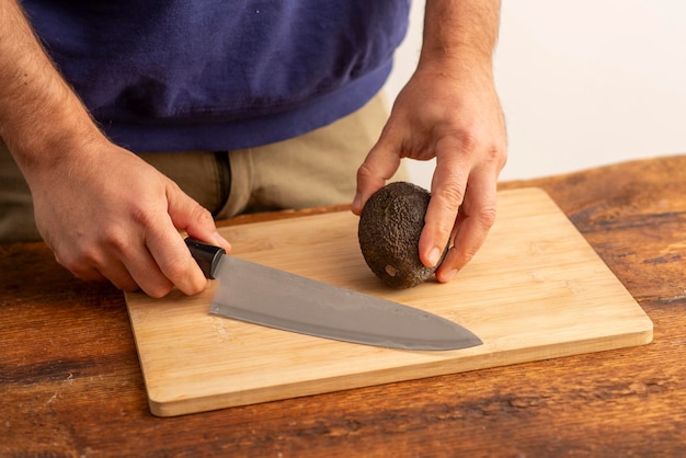 male hands holding cutting avocado on the table