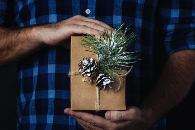 Male hands holding homemade christmas gift dark  Christmas 