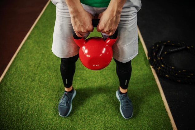 Male hands holding a load and doing a dead lift or squat