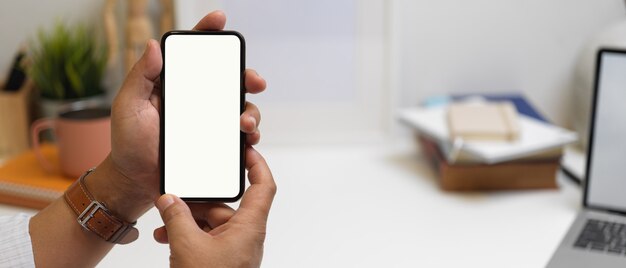 Male hands holding smartphone with white screen