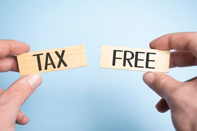 TAX FREE와 함께 두 개의 나무 못을 들고 남성 손