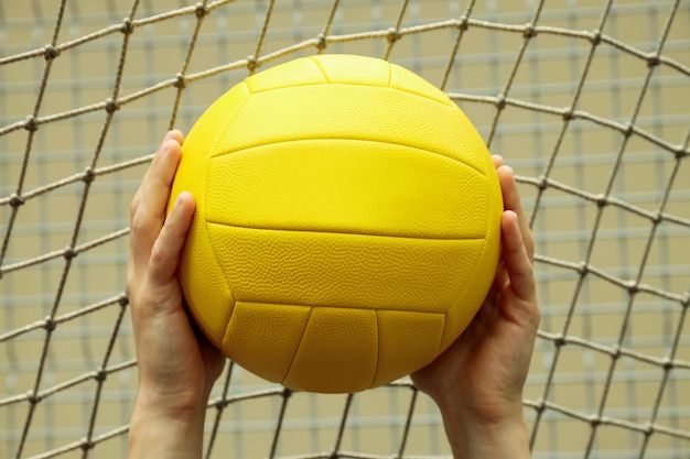 Male hands holding volleyball ball close up