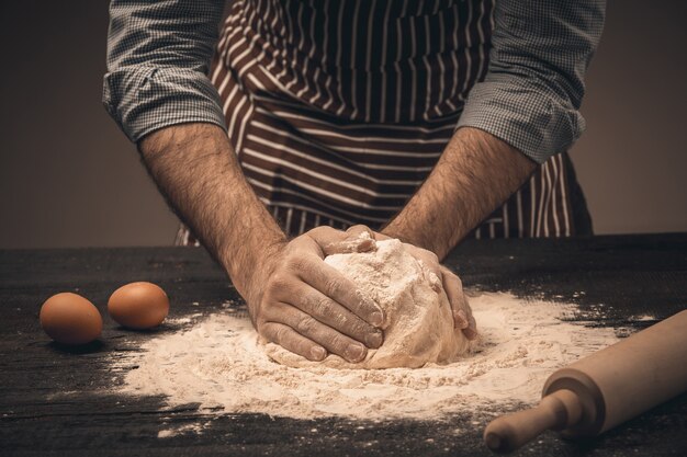 Male hands knead the dough