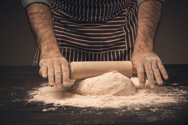 Male hands knead the dough