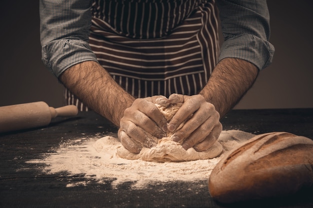 Male hands knead the dough