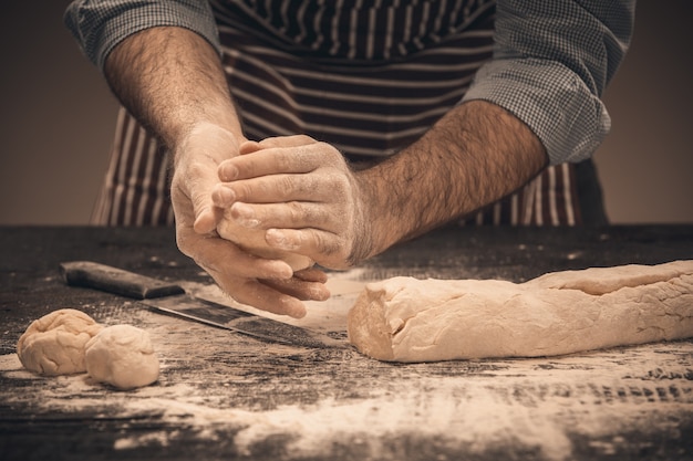 Male hands knead the dough