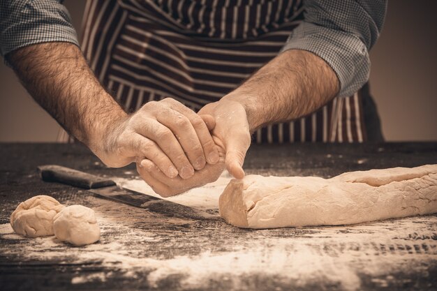 Male hands knead the dough