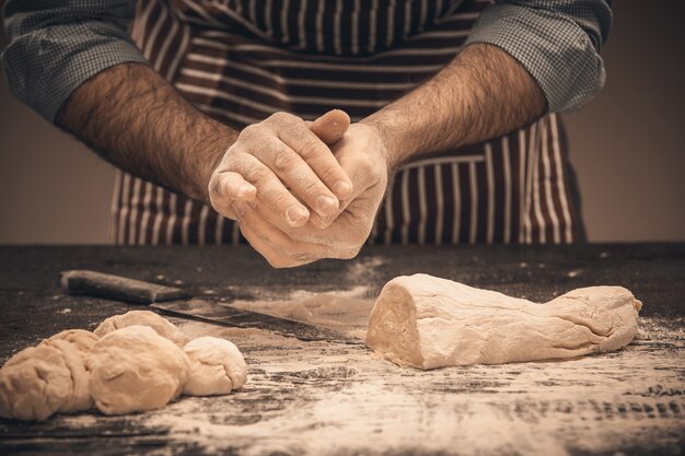 Male hands knead the dough