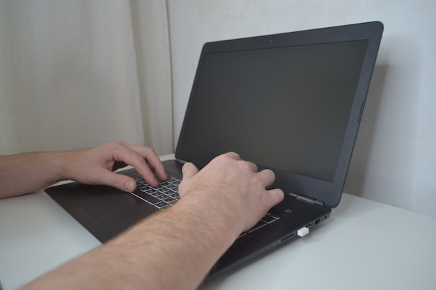 Male hands on a laptop close-up