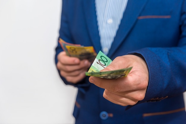 Male hands offering australian dollar banknotes, macro